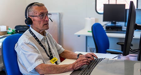 Older man working at a computer.